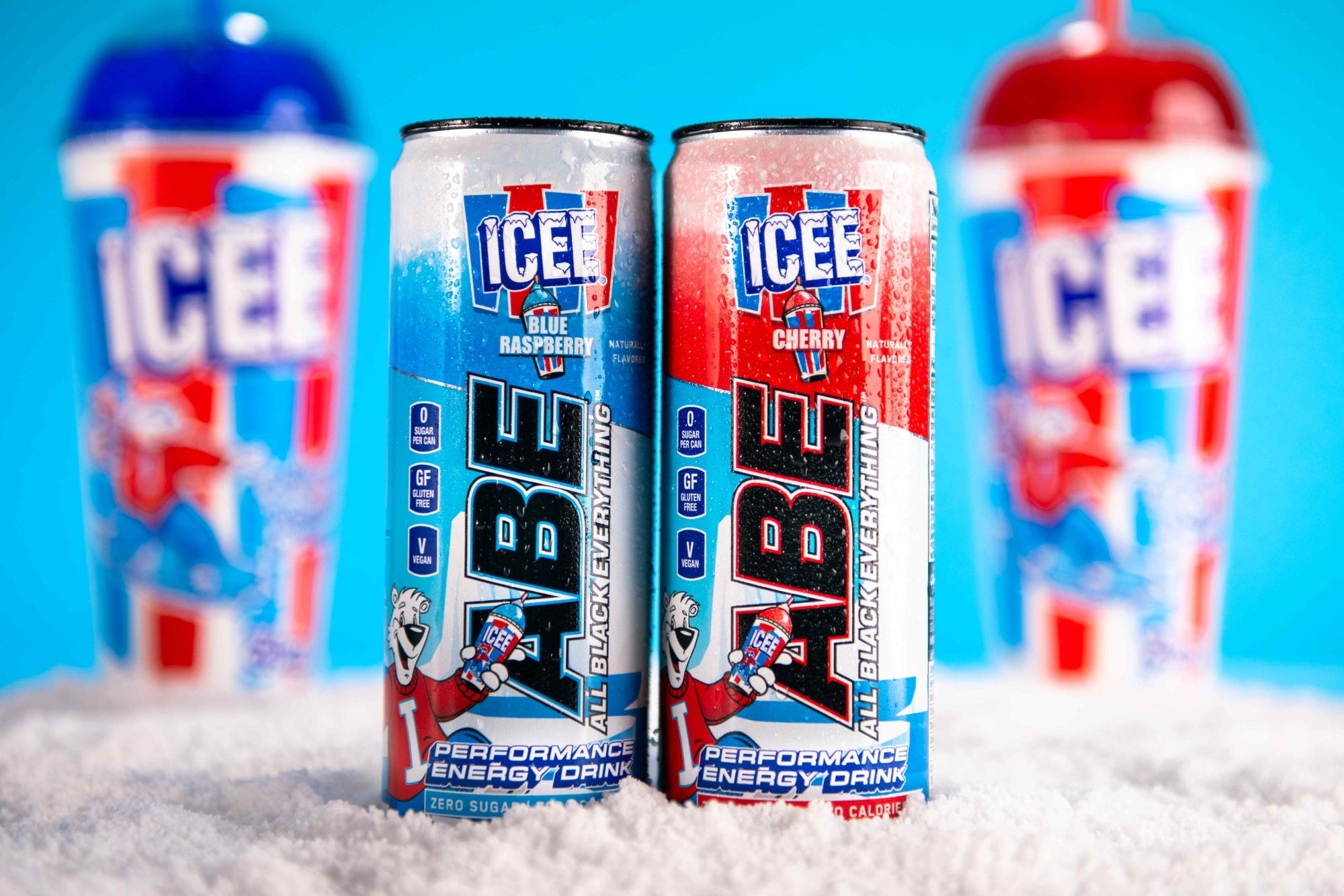 Two cans of ICEE Performance Energy Drink on a blue background with ice cubes.